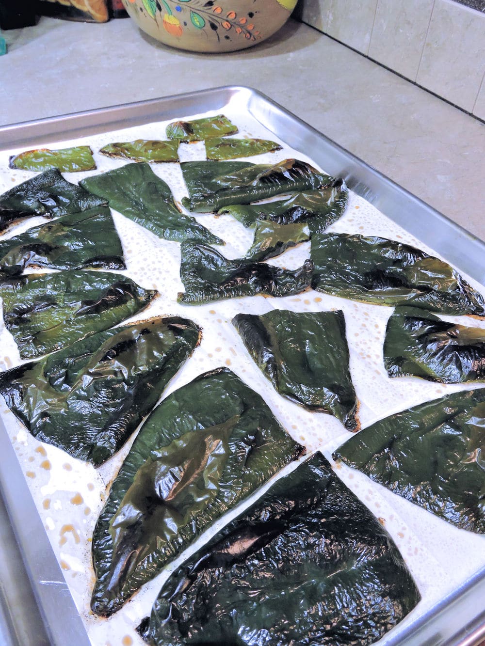 tray of roasted poblanos almost charred enough to peel