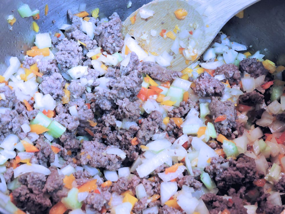 sauteing celery, onions and bell pepper with cooked ground beef