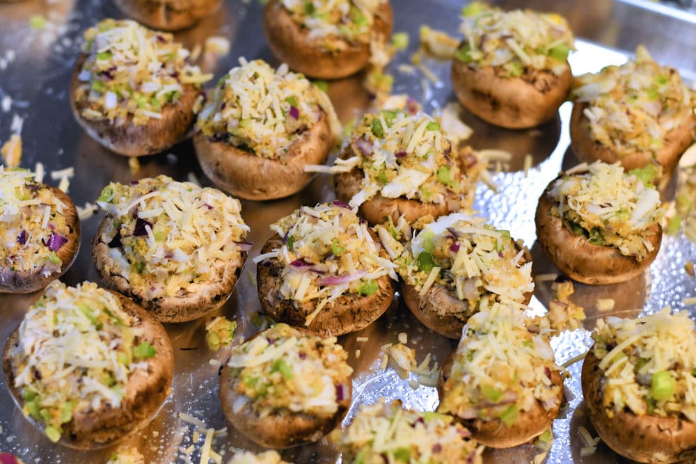 mushroom caps, filled with crab filling on a baking sheet