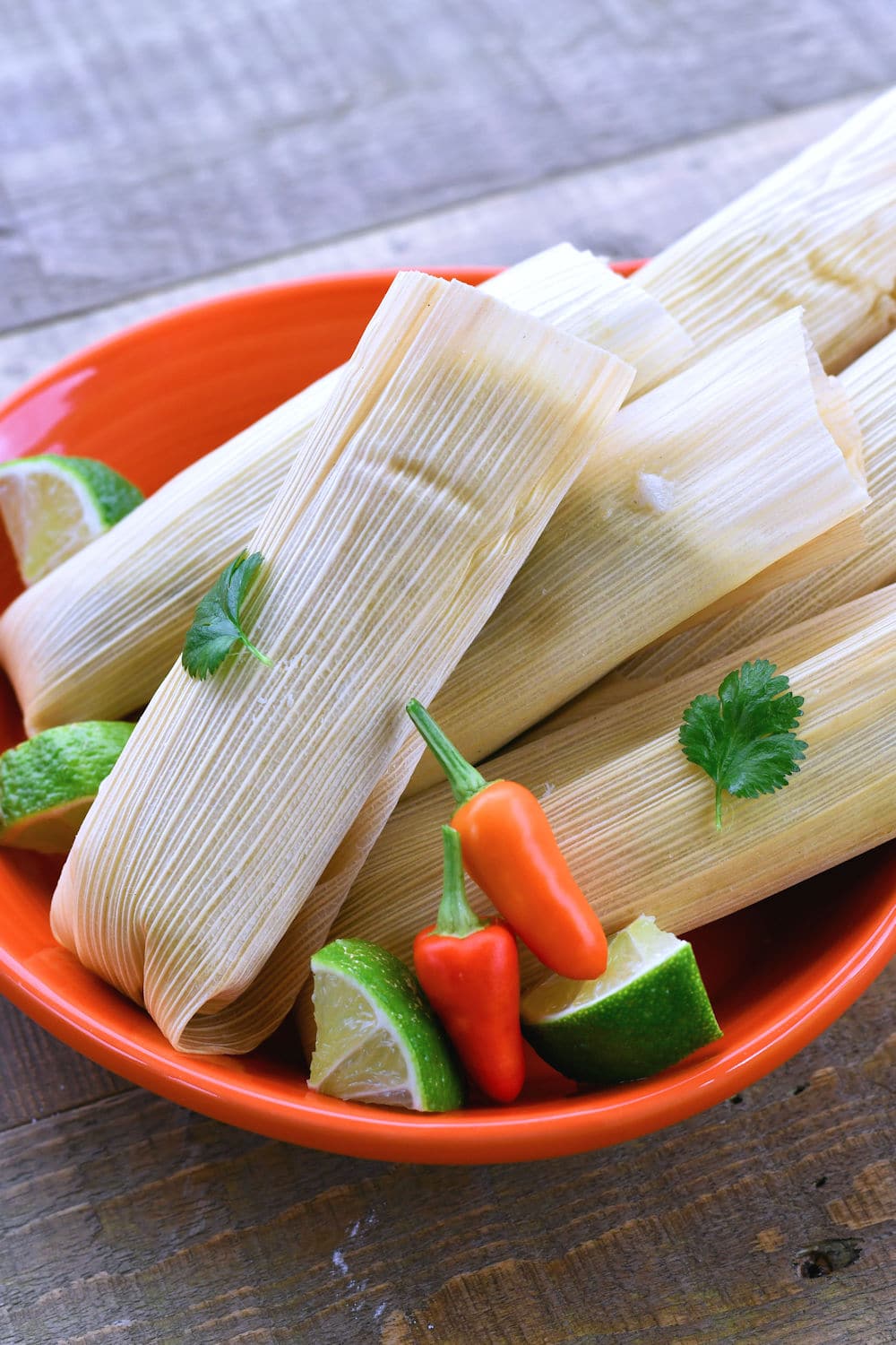 24Bite: Beautiful chicken tamales wrapped in corn husks and served with lime cilantro and Thai chiles
