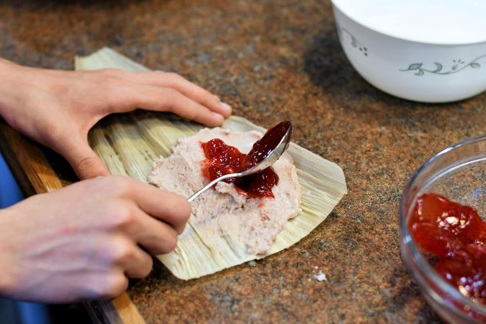 24Bite: spreading raspberry filling on top of masa dough for sweet dessert tamal