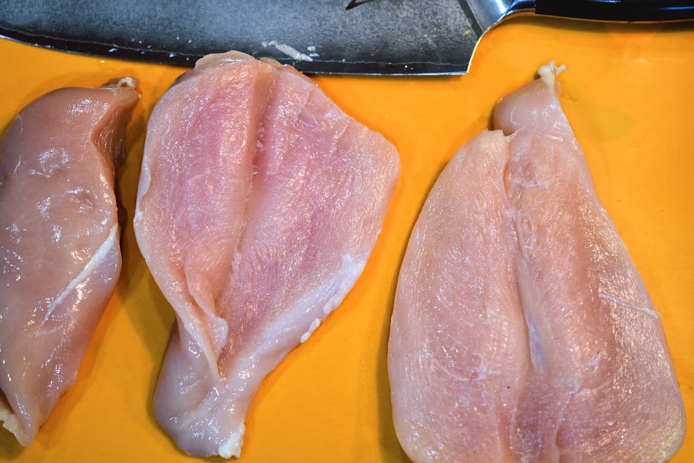 24bite: three chicken breasts and knife showing how to butterfly the chicken