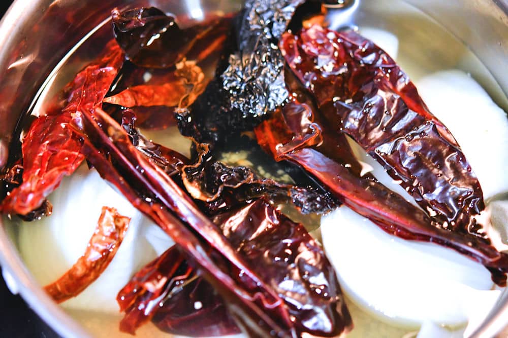 California and arbol chiles in a pan with water to reconstitute for chile colorado sauce