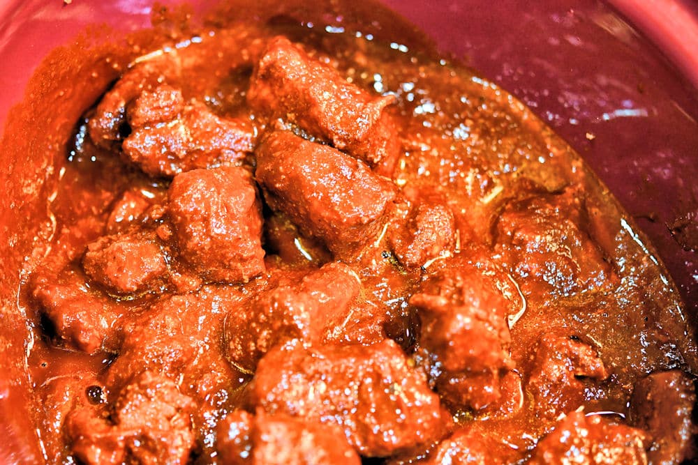 Mix the red chile sauce with the pork bites before slow cooking.