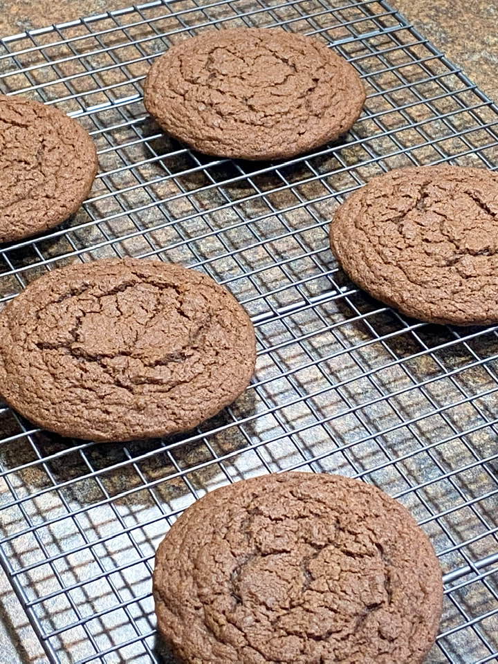 Chocolate cookies cooling on a wire rack.