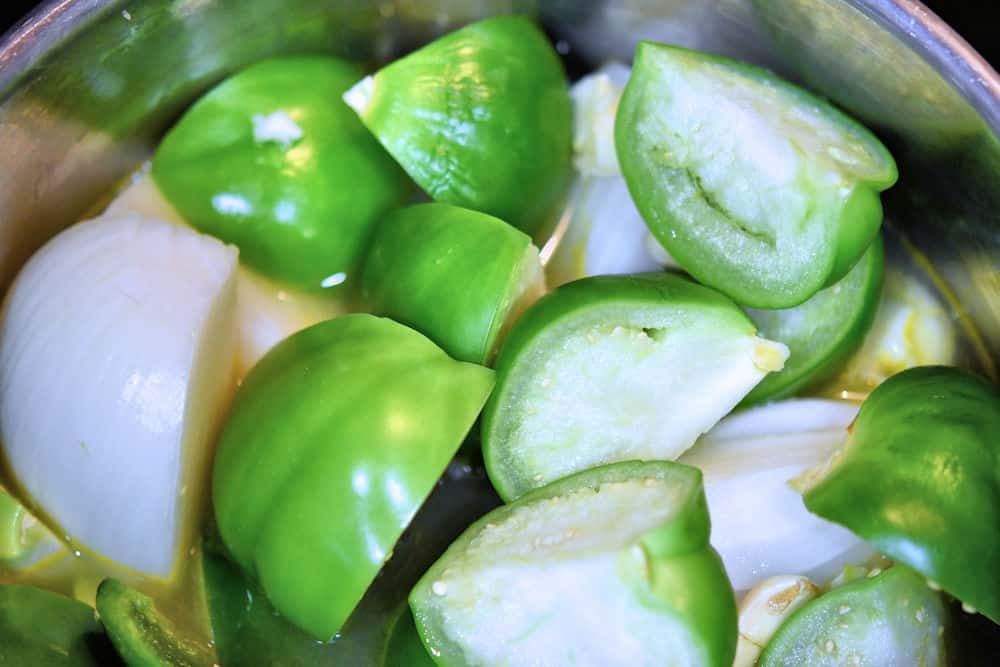 Cook the tomatillos, onion, chiles and garlic in a saucepan on the stove top.
