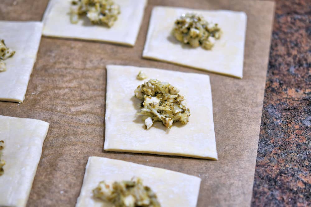 Cut the puff pastry into squares and place a teaspoon of filling in the center of each one.
