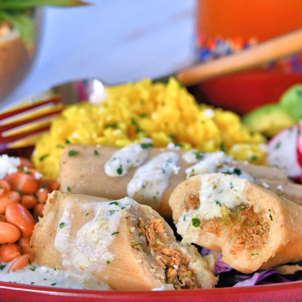 chicken enchiladas with jalapeno crema served with beans and rice