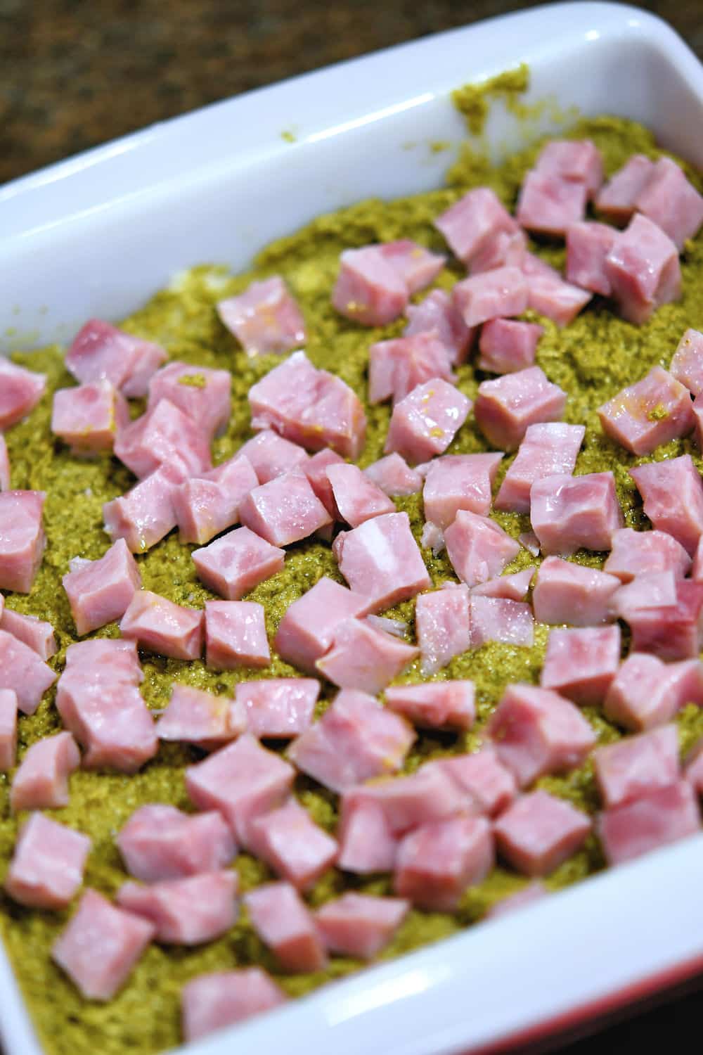 cubed ham sprinkled over the top of the pesto for the sliders