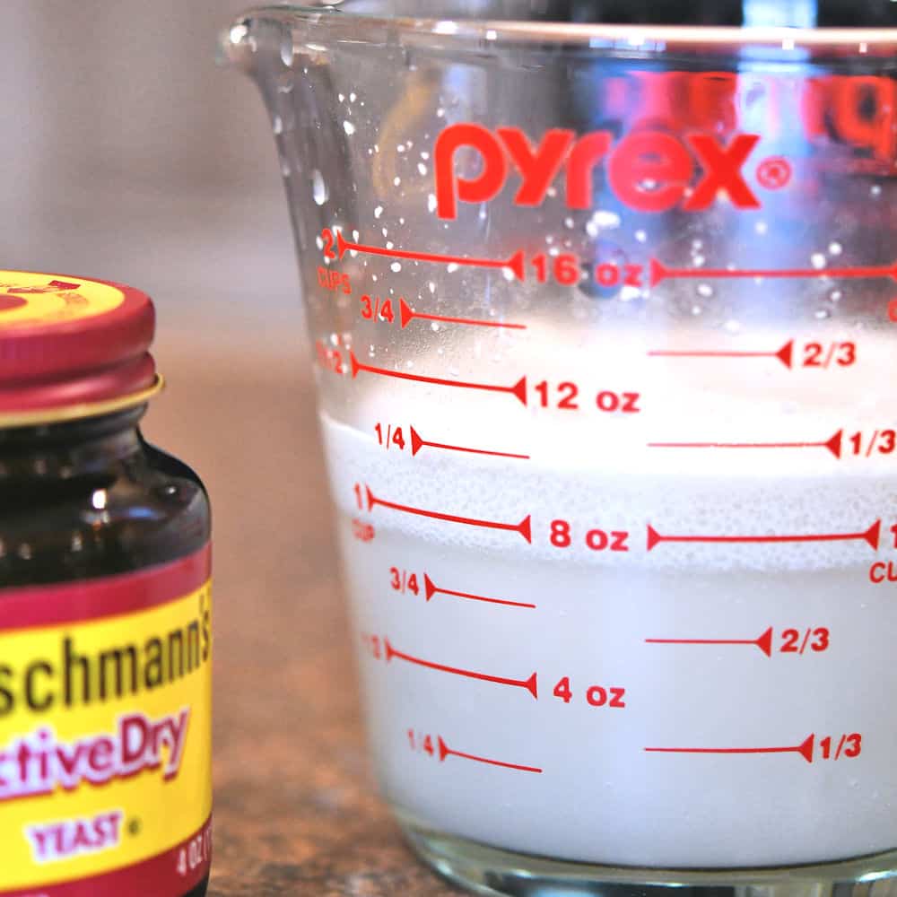 A glass measuring cup with yeast, water and sugar, to demonstrate proofing