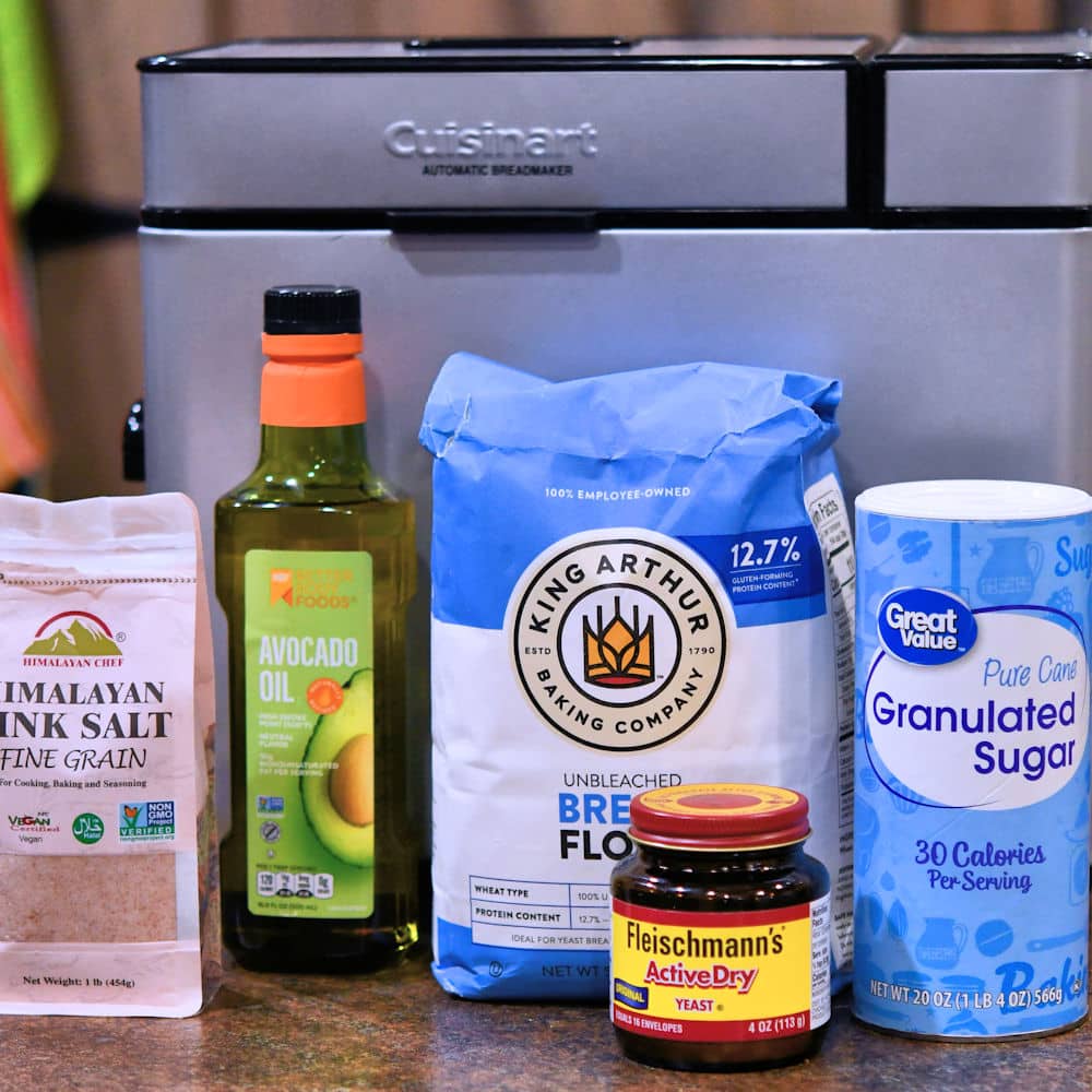 ingredients for pizza dough recipe displayed on a countertop with a cuisinart bread machine