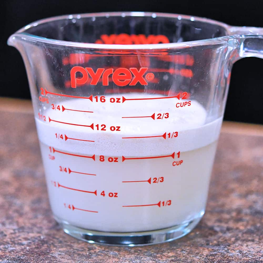 a measuring cup with yeast proofing