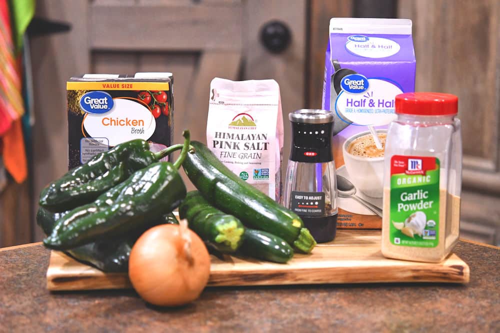 zucchini and spicy green chiles with other ingredients for soup on a cutting board