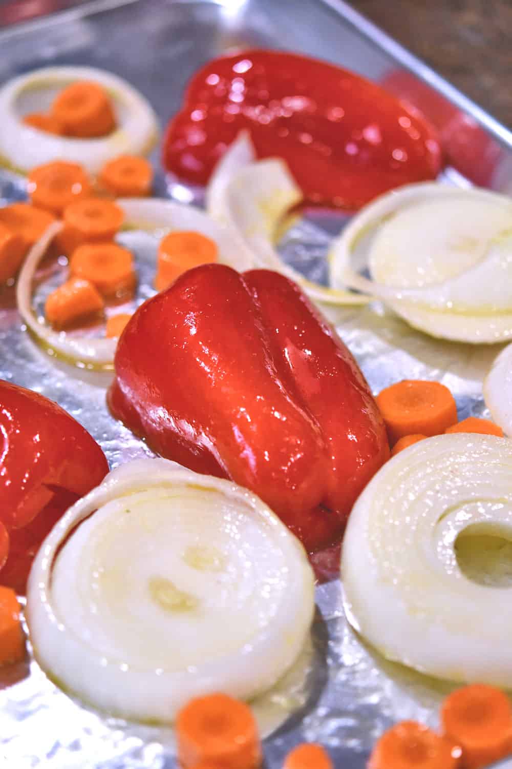 red peppers, onions and carrots on baking sheet for roasting