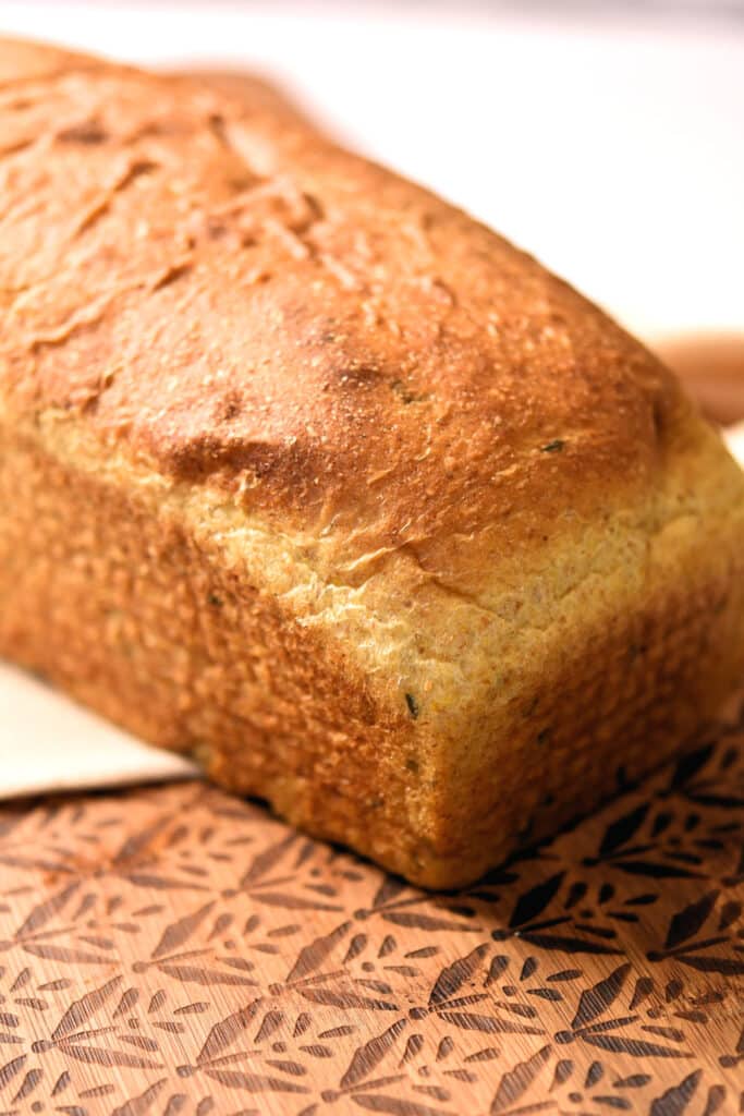 beautiful unsliced loaf of savory honey mustard bread on a cutting board