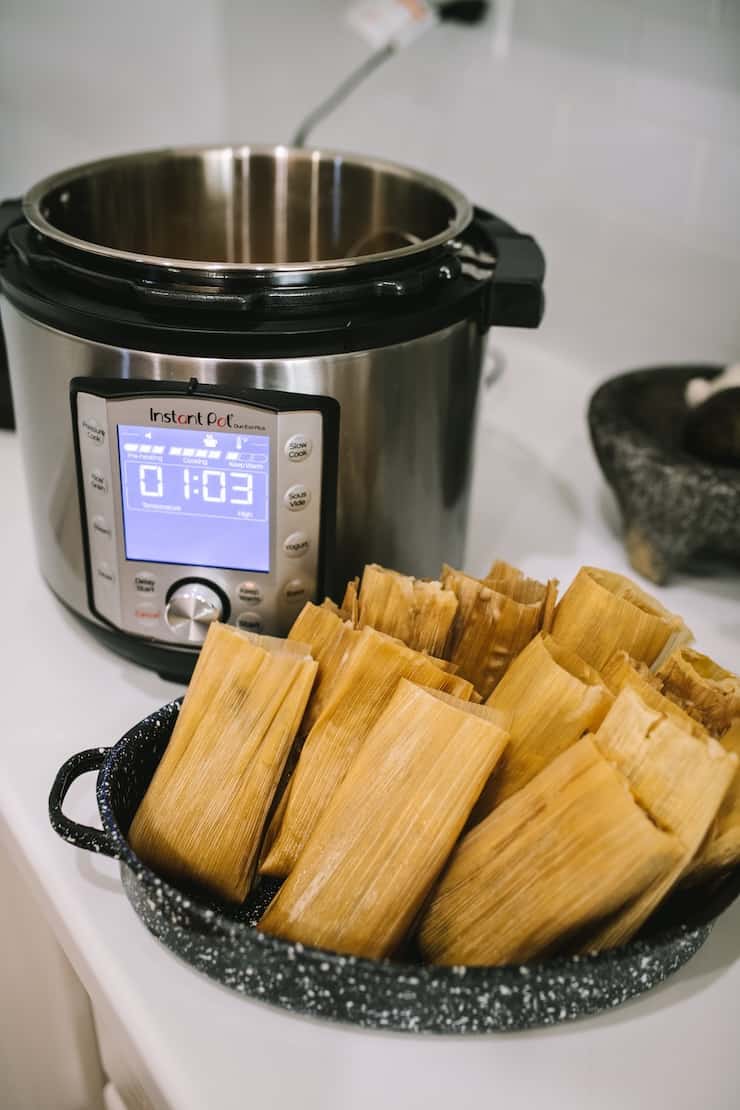 Pork green chile tamales on a counter beside an Instant Pot