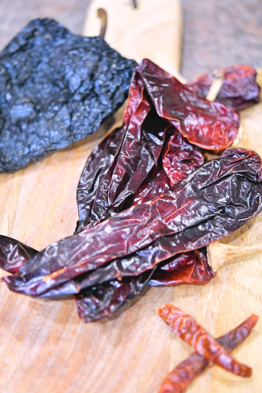 ancho, Anaheim and Arbol chiles on a wooden cutting board