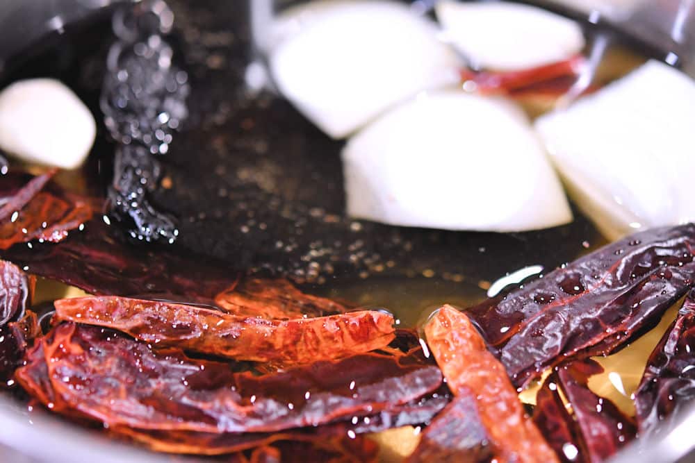 Mexican dried chiles in a sauce pan to be reconstituted with boiling water