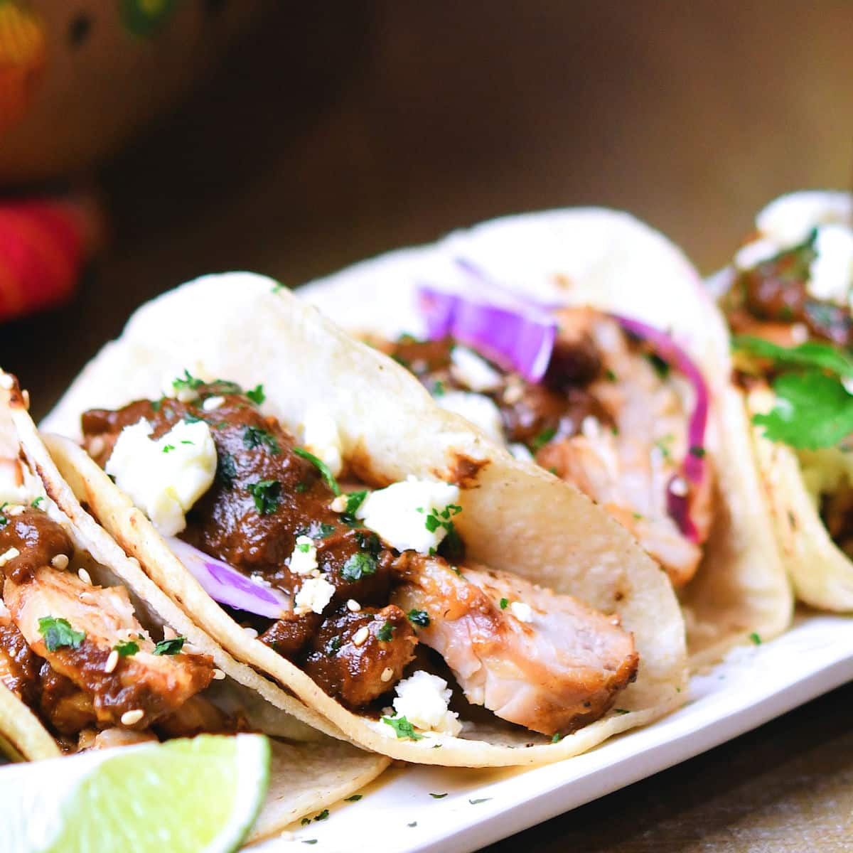 Sliced chicken thigh in chicken mole sauce in a corn tortilla