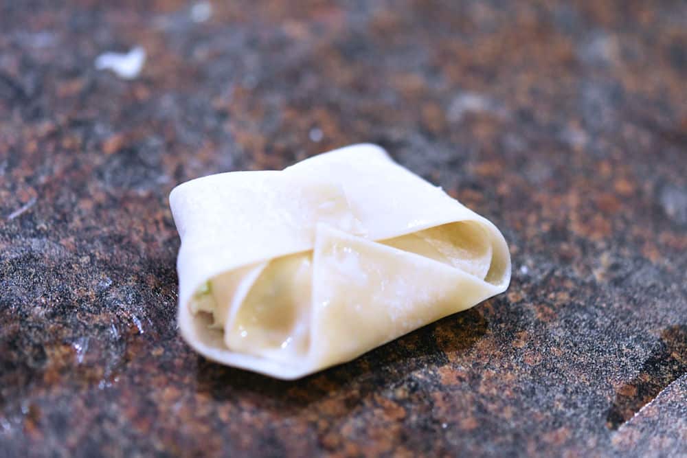 a wrapped rangoon ready to be fried or baked