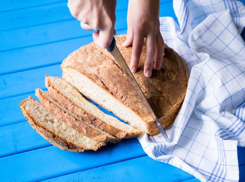 closeup of large round loaf of bread with slicing being cut © to 123rf.com