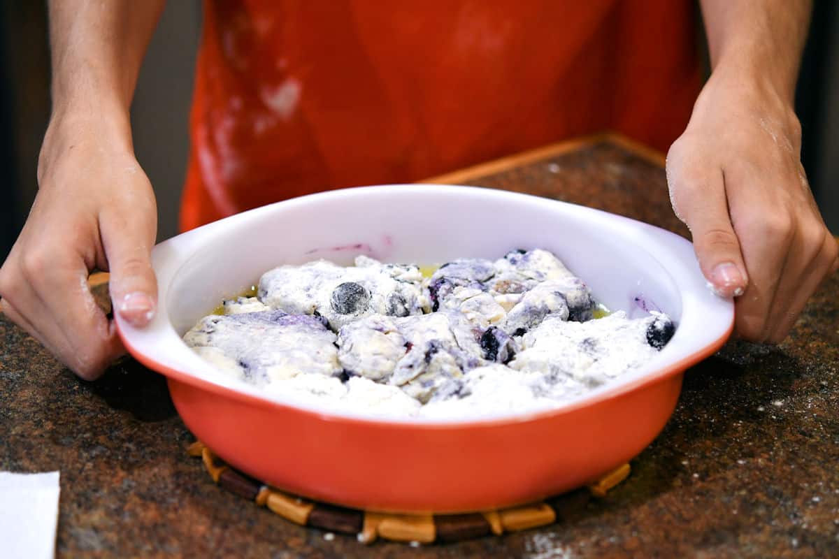 blueberry biscuits cut out in a cake pan, ready for the oven