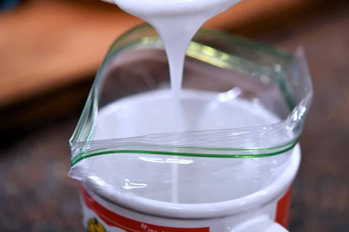 pouring powdered sugar glaze into a ziploc bag