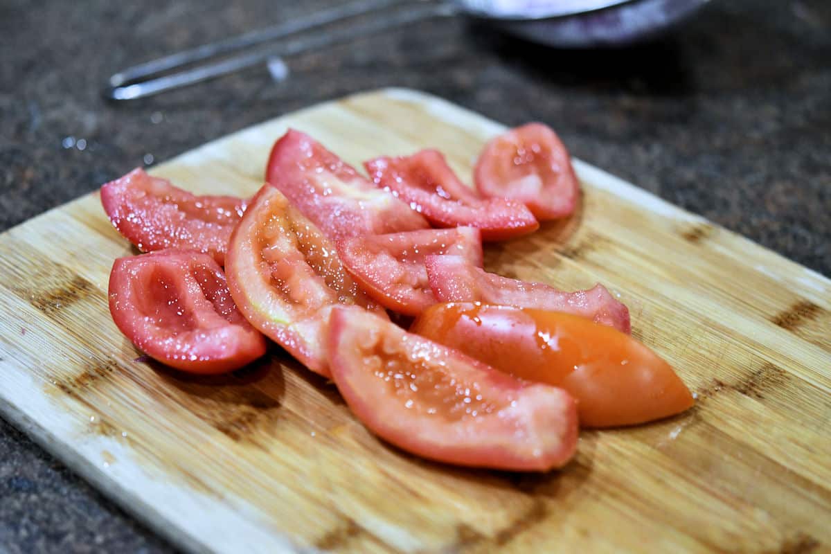 quartered tomatoes, on a cutting board