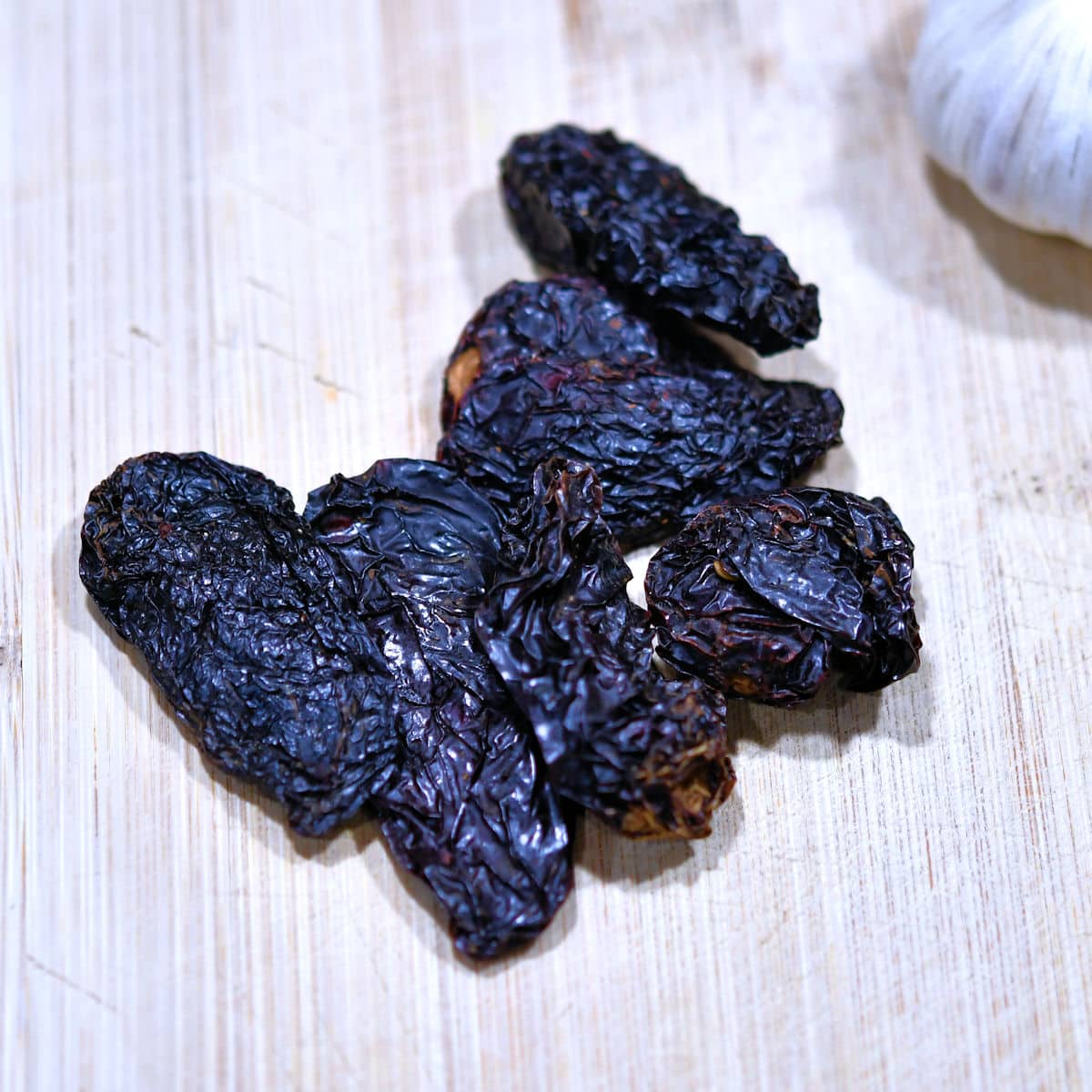 handful of dried chipotle peppers on a cutting board