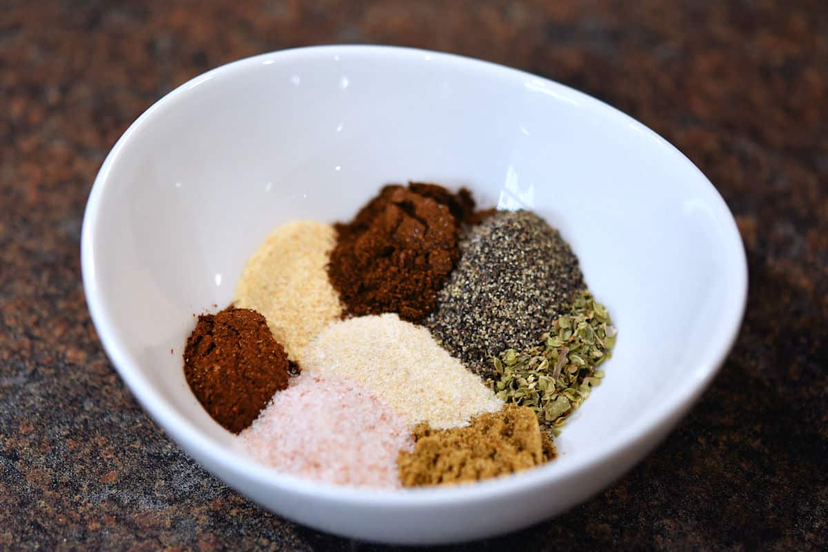 a little white bowl with a variety of fajita spices