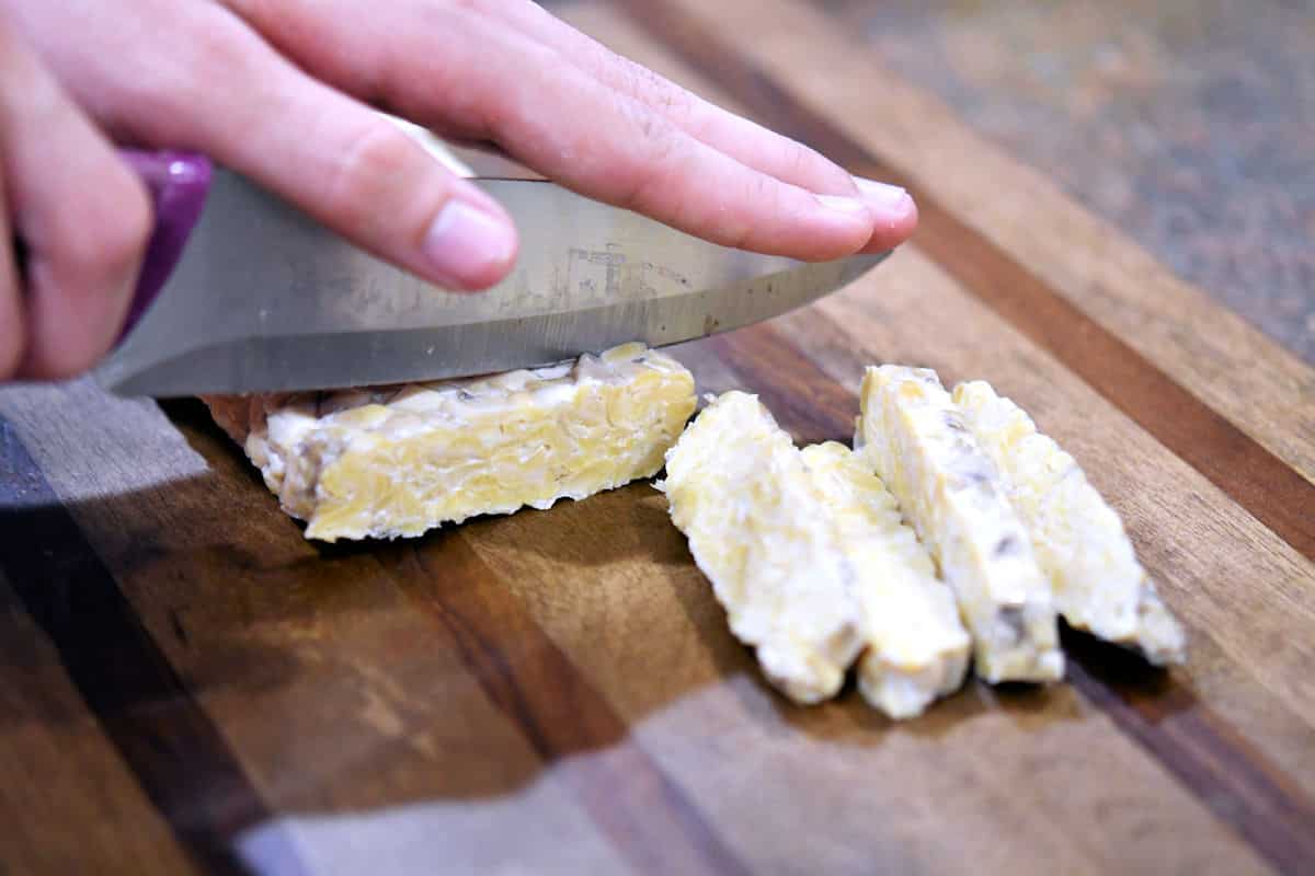 cutting tempeh into thin slices to be used in fajita tacos