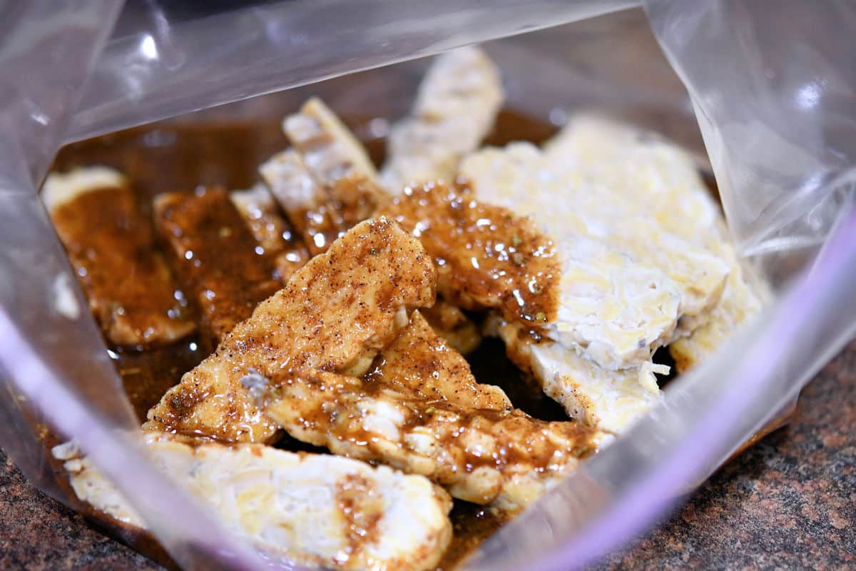 a ziploc bag with sliced tempeh and marinade, ready for the refrigerator