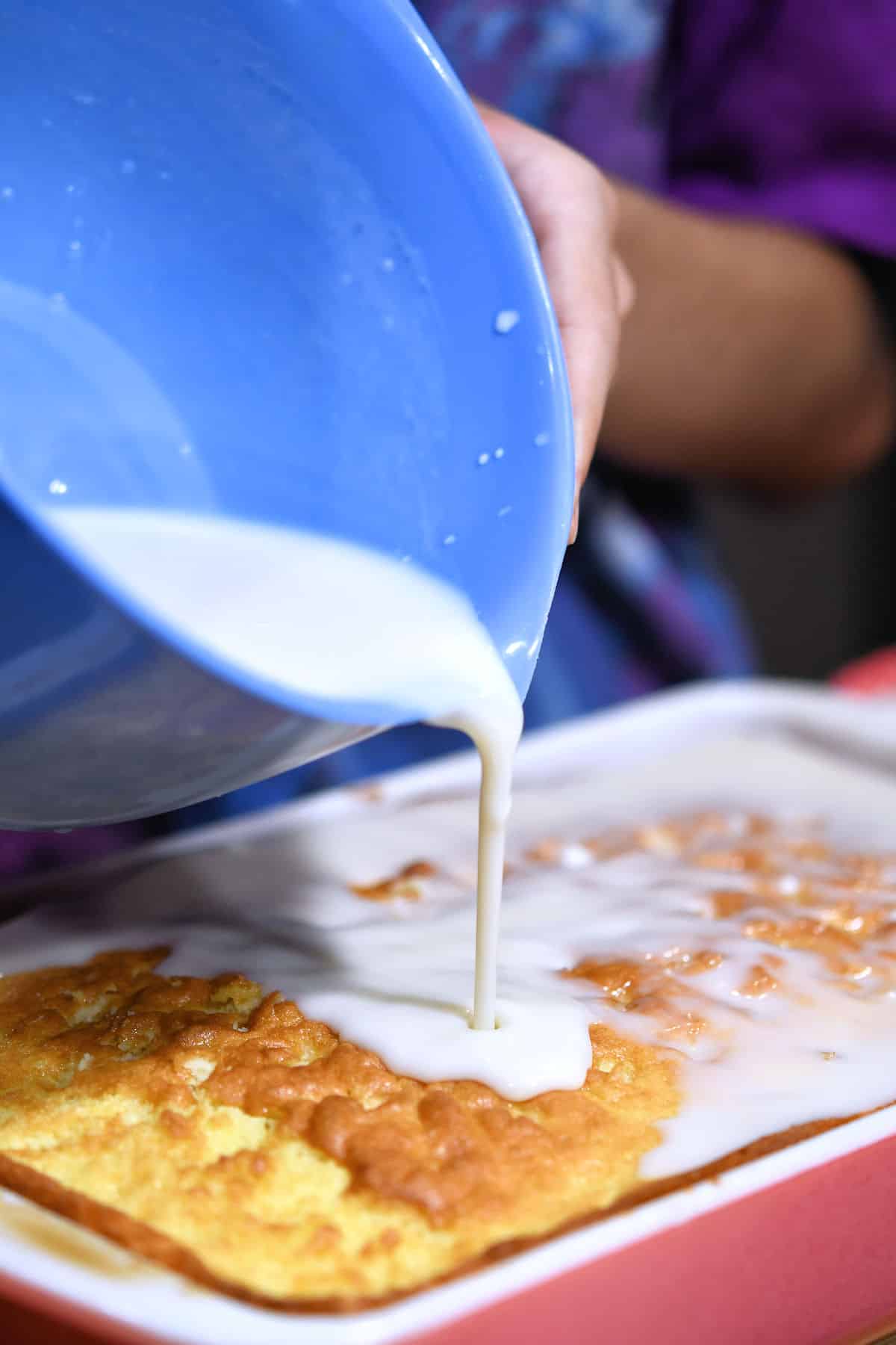 bowl of soaking milks, slowly pouring over hot cake