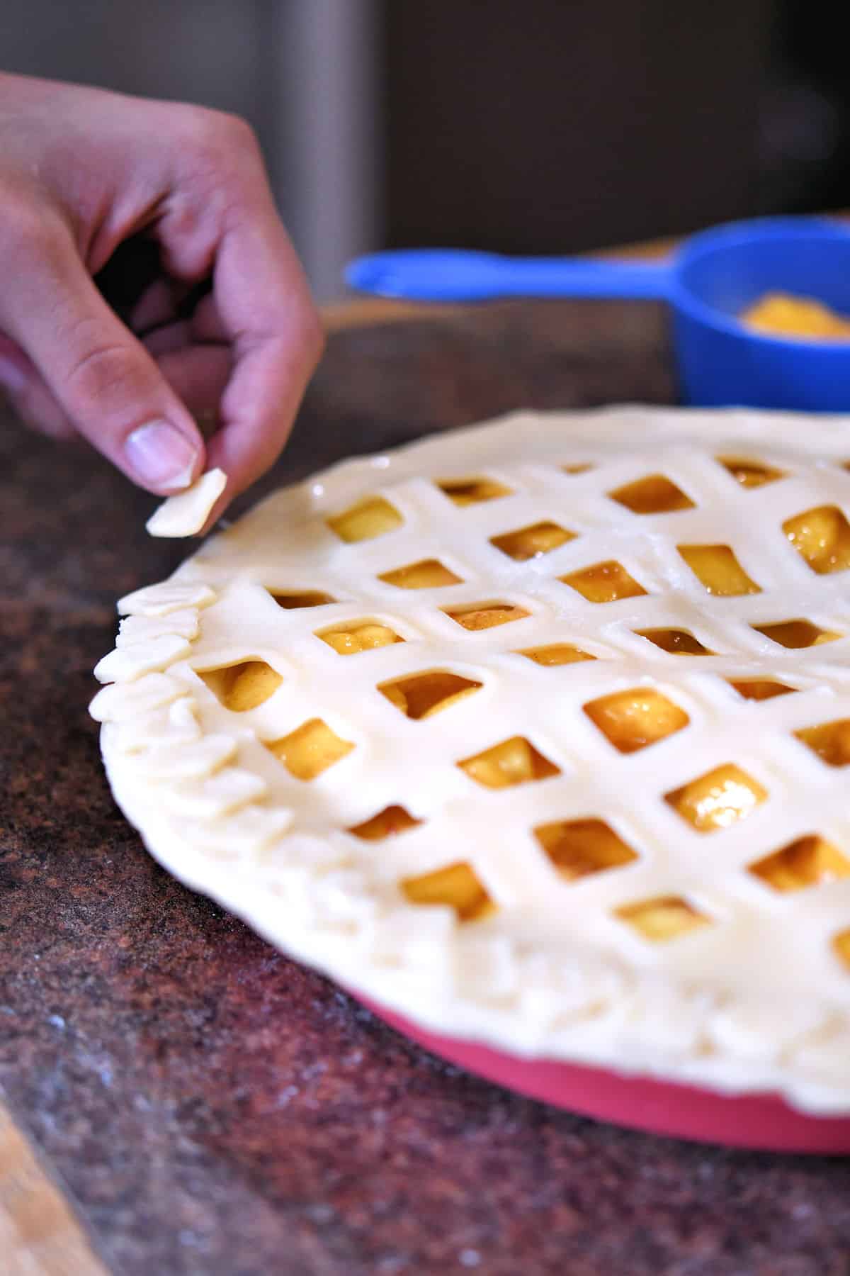 attaching small pieces of dough to the edge of the pie as decorative bits