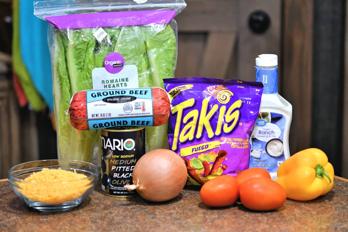 all ingredients for takis taco salad from the recipe card, displayed on a counter top.