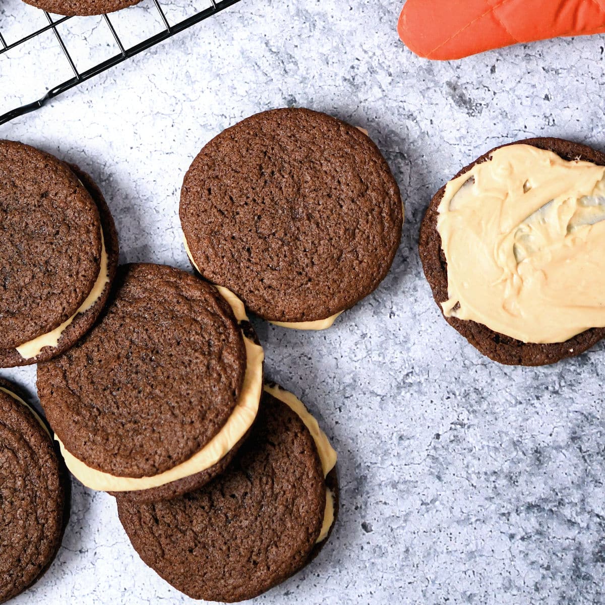 chocolate sandwich cookies being layered with peanut butter frosting