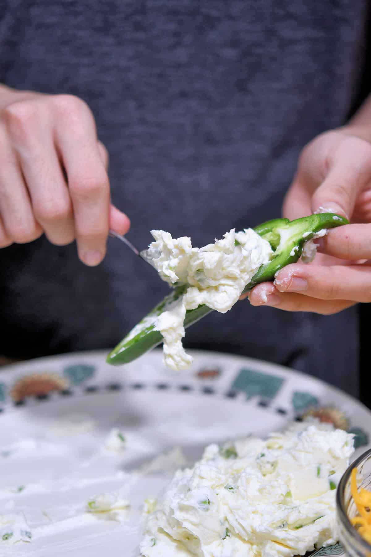 filling the inside of a jalapeno pepper with cream cheese mixture