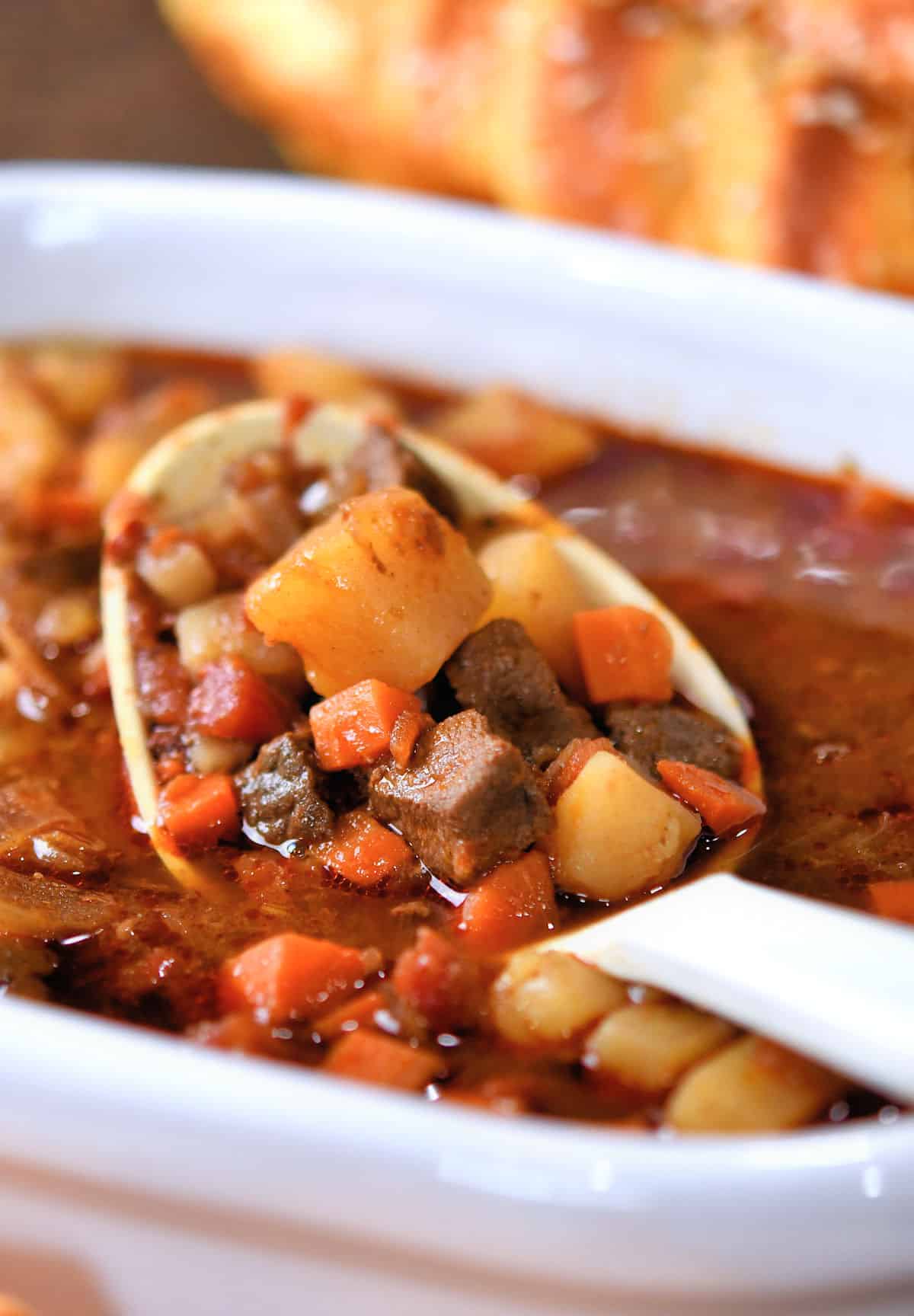 closeup of venison stew being ladled from a serving bowl