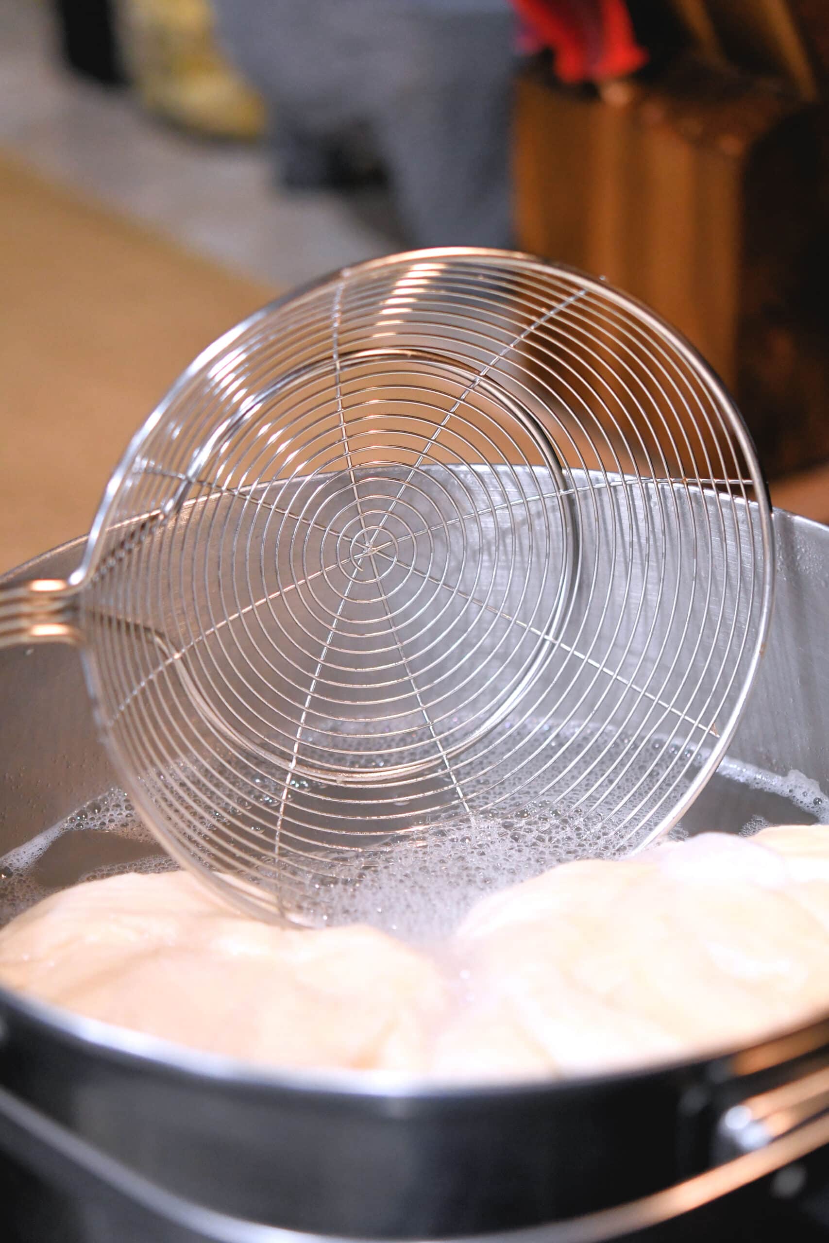 using a spider strainer to remove pretzels from boiling water