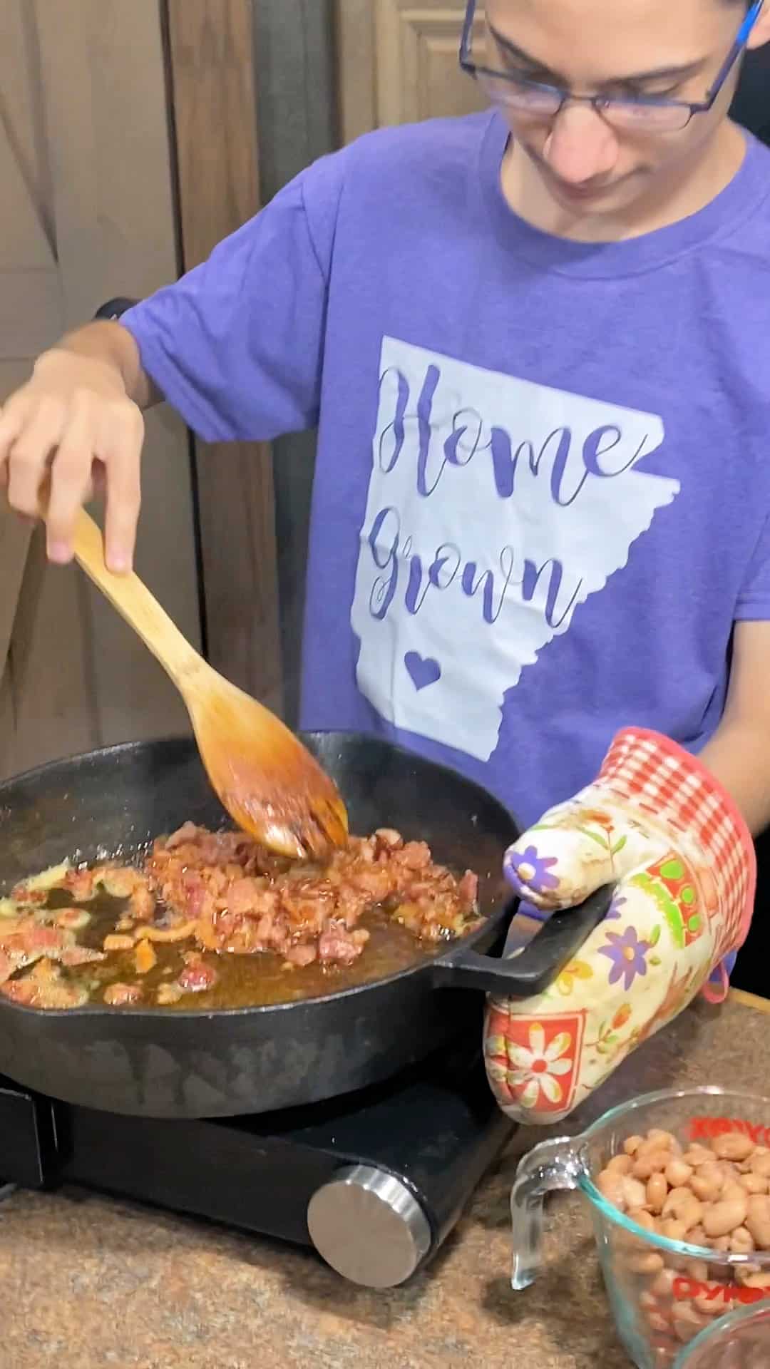 cooking bits of bacon in an iron skillet