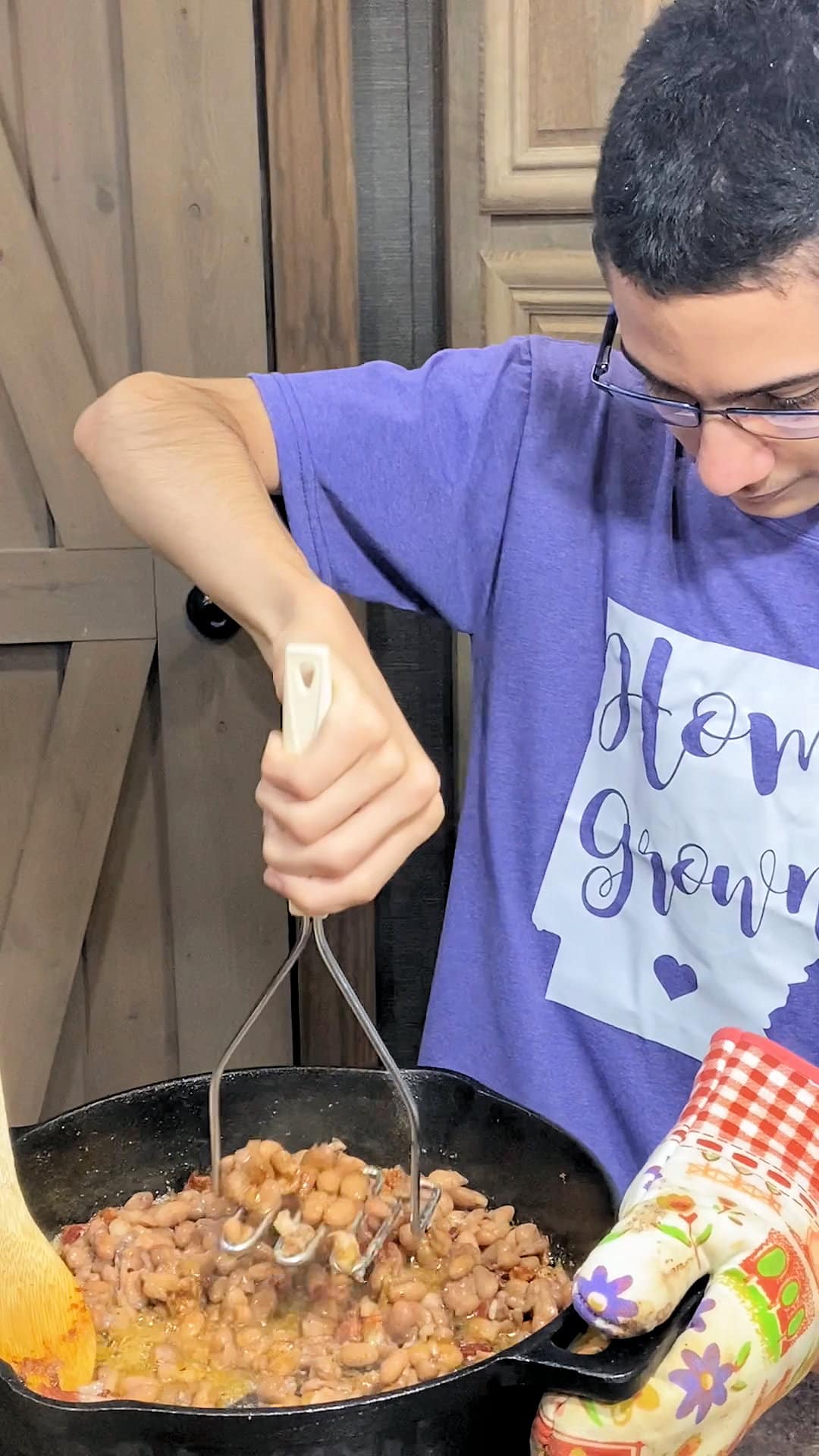 using a potato masher to mash the refried beans