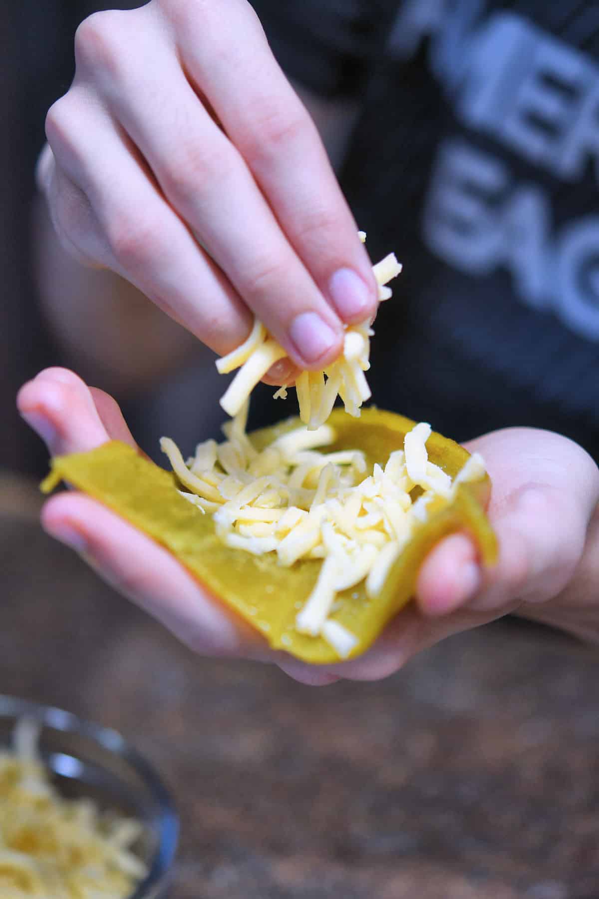 placing a small handful of shredded cheese inside a green chile