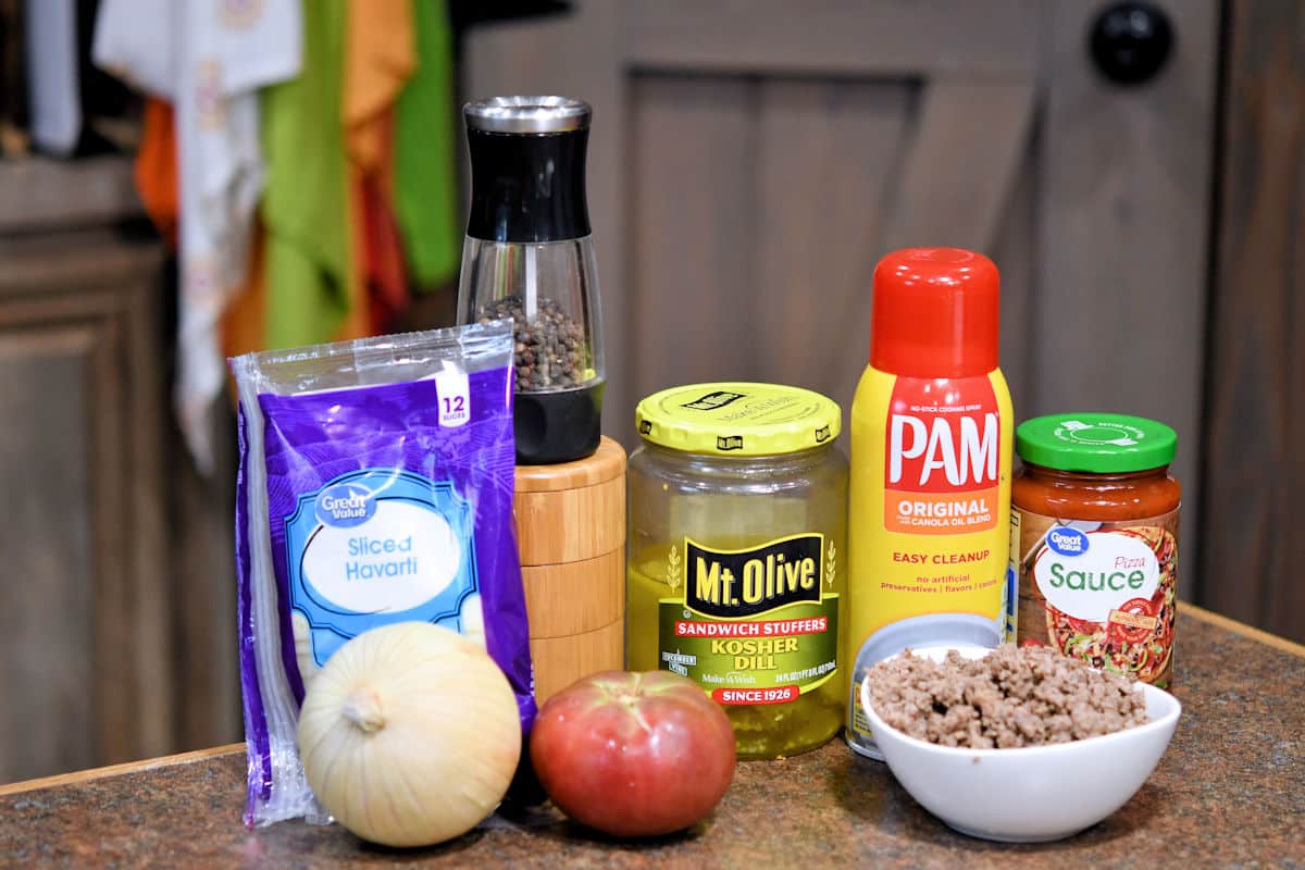 ingredients of cheeseburger pizza on a countertop