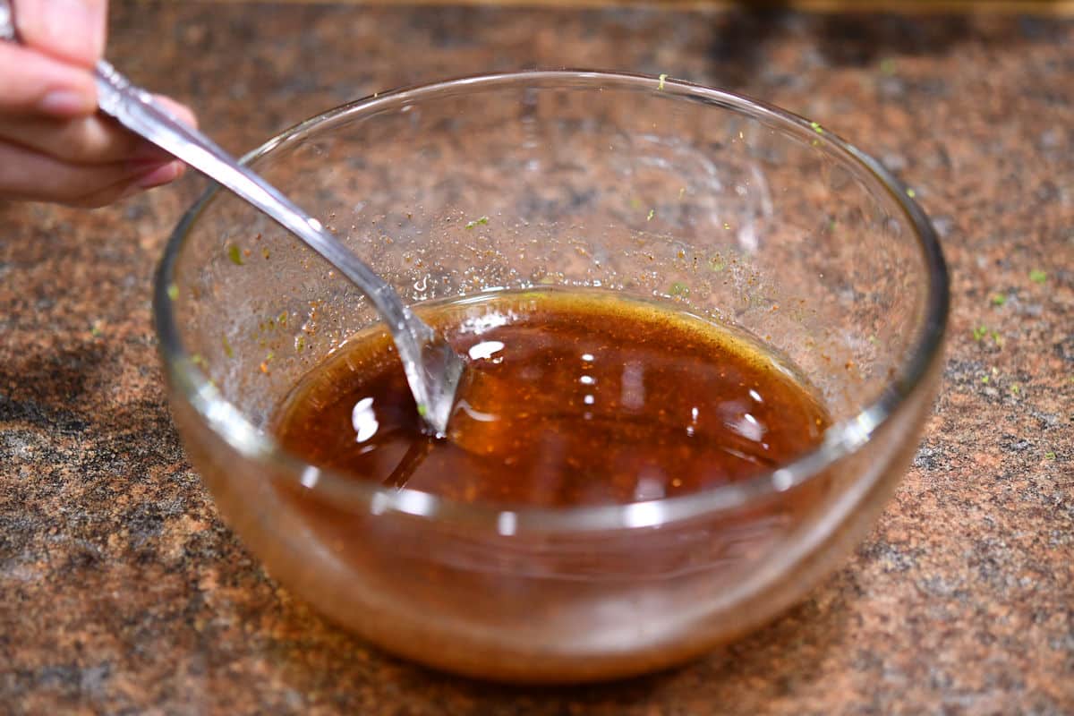 mixing honey lime vinaigrette in clear glass bowl