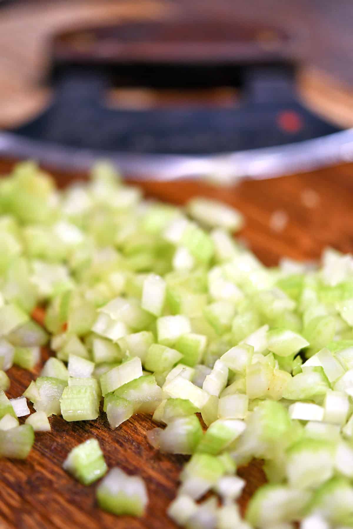 closeup of diced celery on a cutting board with ulu in the background
