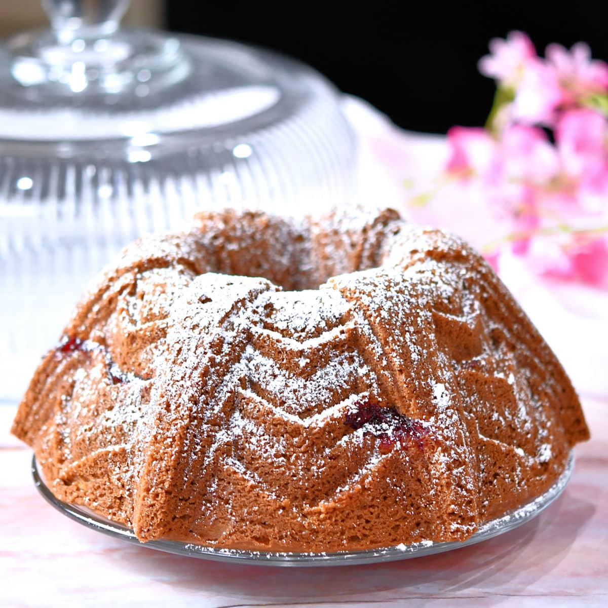 Raspberry bundt cake, freshly dusted with powdered sugar.