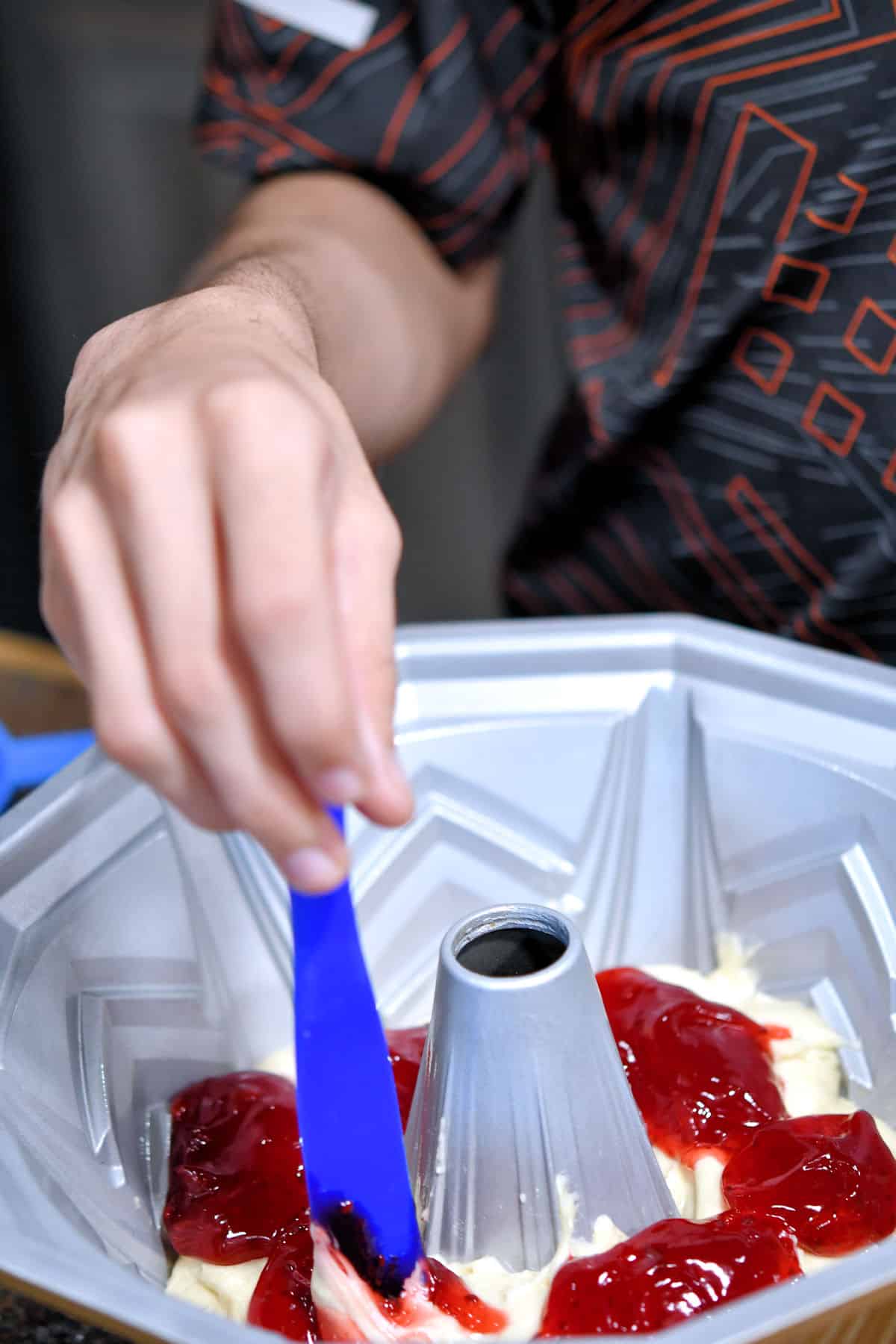 layering and swirling the raspberry filling with a silicone spurtle