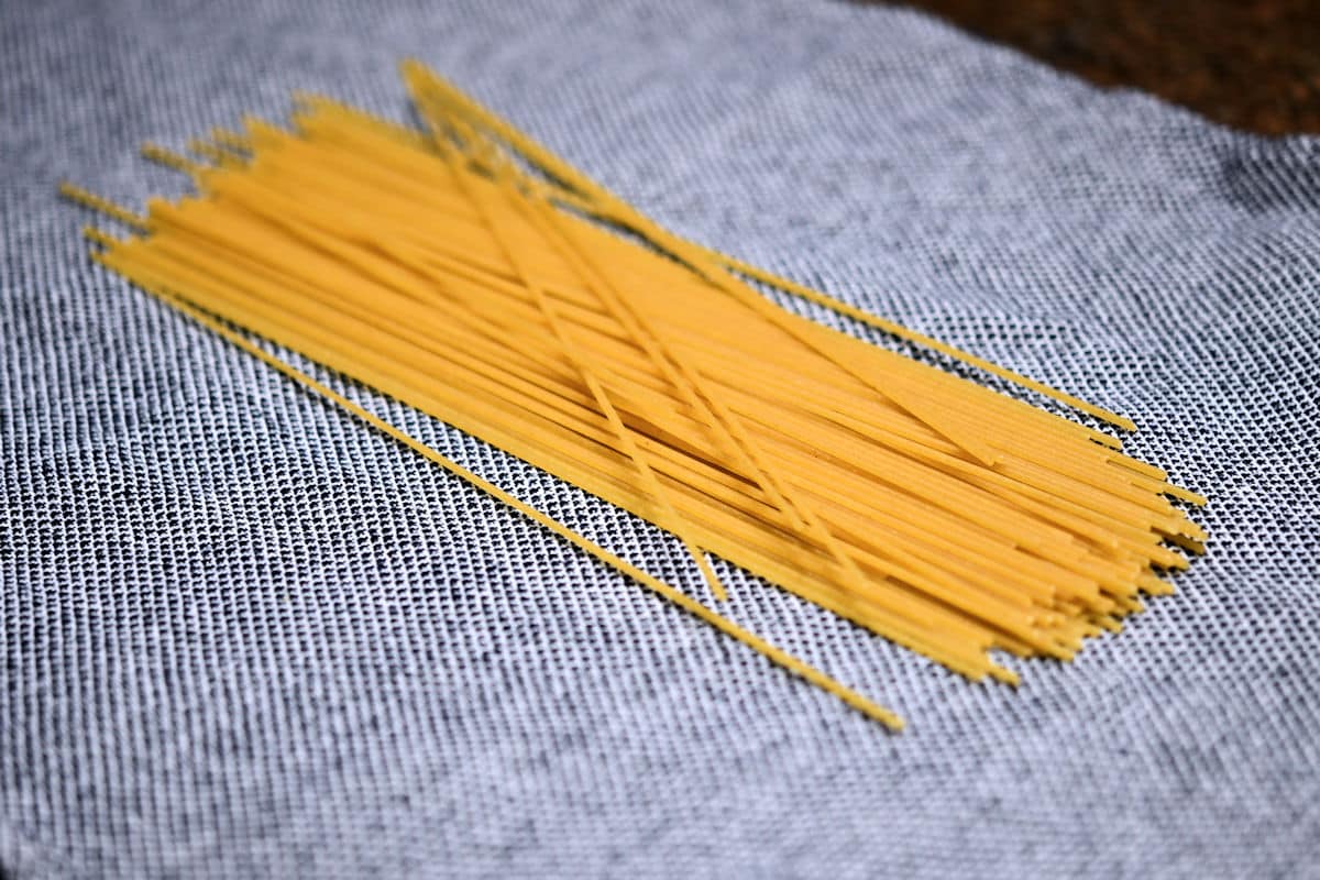 vermicelli pasta on a dish towel to roll up and break before cooking