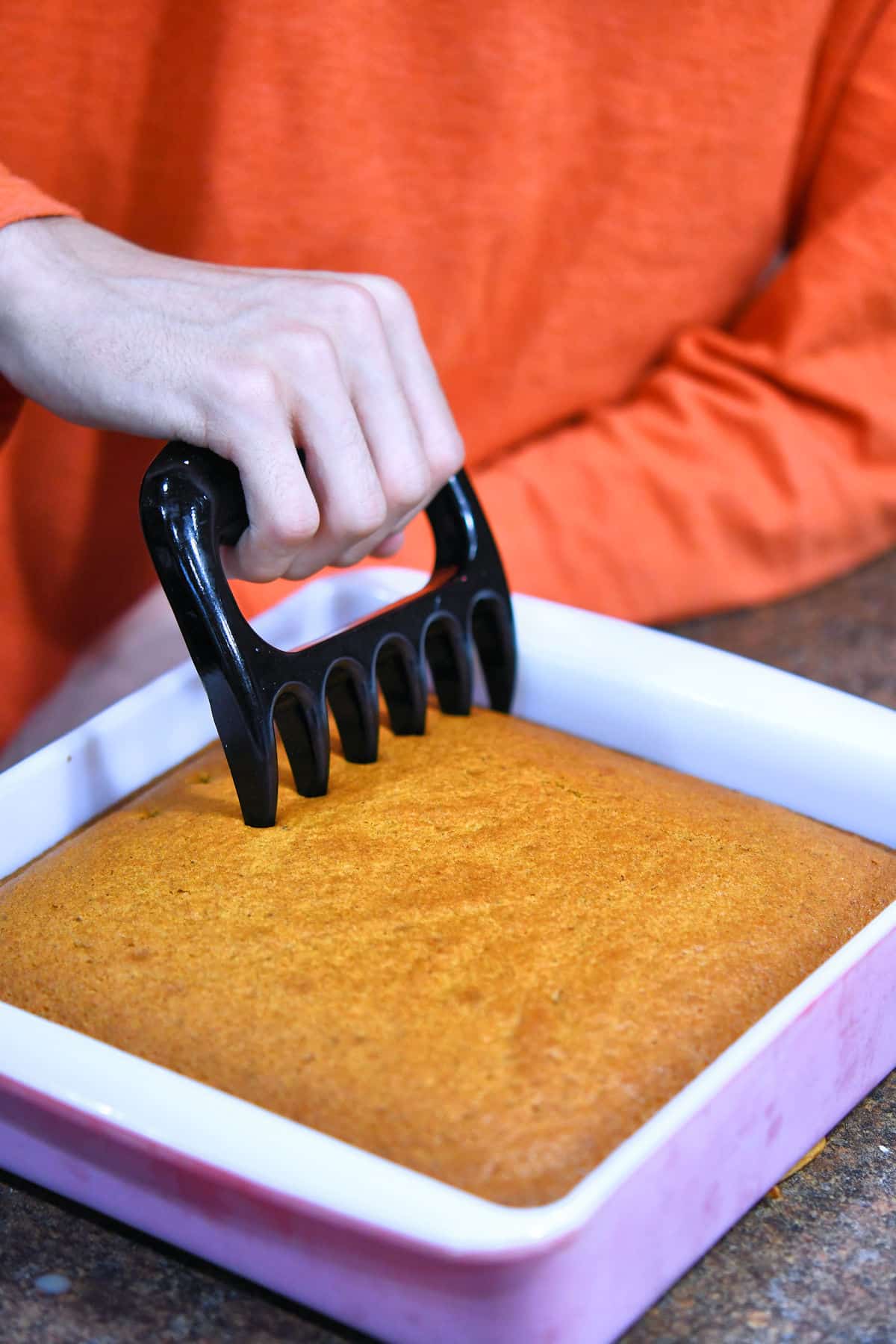 closeup of poking holes in a pumpkin spice cake