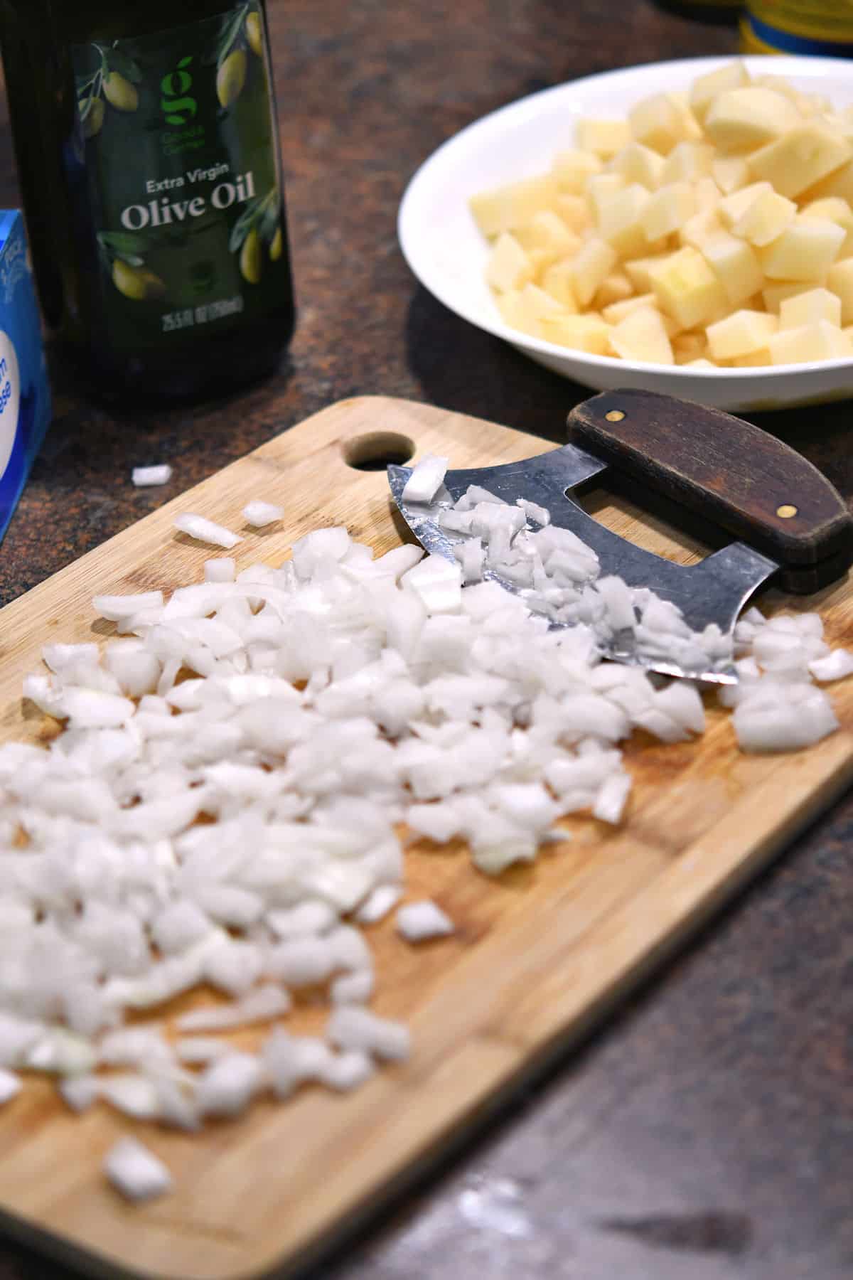 chopped onions and potatoes on a cutting board